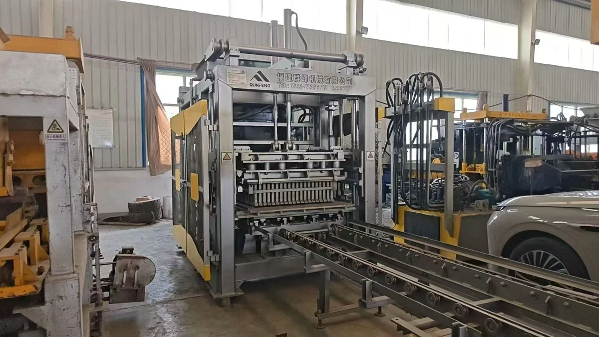 QGM (Qunfeng) block making machine with its hydraulic system and output conveyor visible